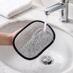 Pet hair removal mitt being rinsed under a tap